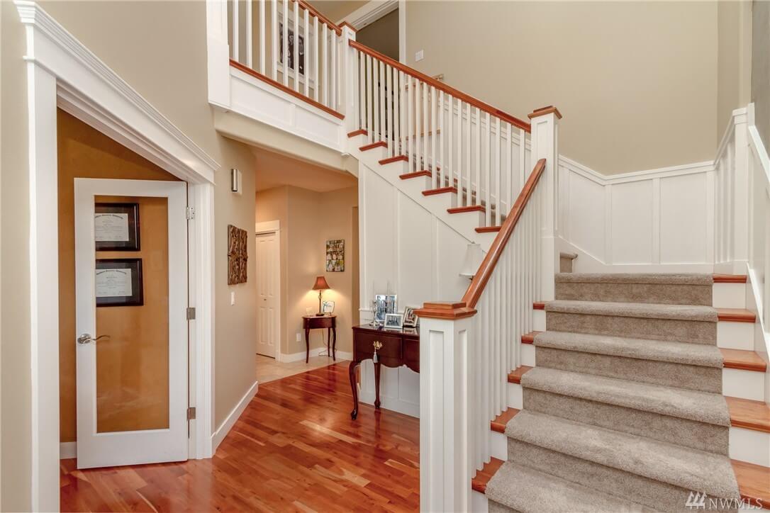 freshly painted staircase and foyer with white wainscoting and wood railings in Cranberry Township, PA